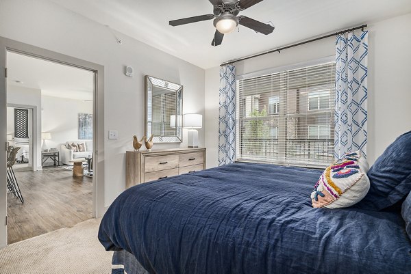 Cozy bedroom with large windows and modern decor at Peak 83 luxury apartments