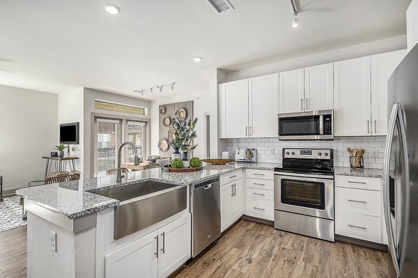 Modern kitchen with stainless steel appliances at Peak 83 luxury apartments