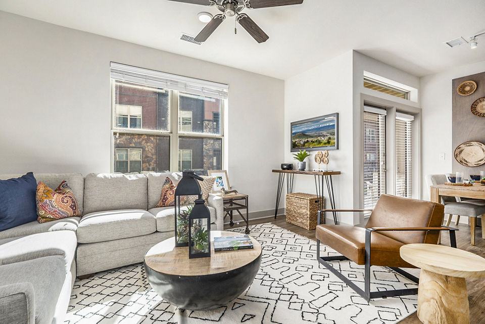 Modern living room with stylish furniture and large windows at Peak 83 Apartments in luxury Greystar community