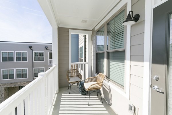 Contemporary outdoor patio at Annabelle on Main Apartments featuring stylish seating and lush greenery