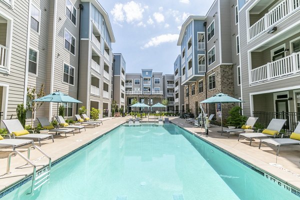 Relaxing poolside area at Annabelle on Main Apartments with plush loungers and lush landscaping