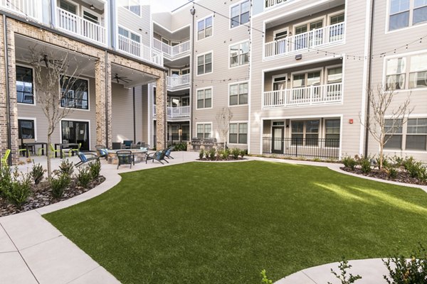Charming courtyard with lush greenery and seating at Annabelle on Main Apartments, offering luxury living in the heart of the community