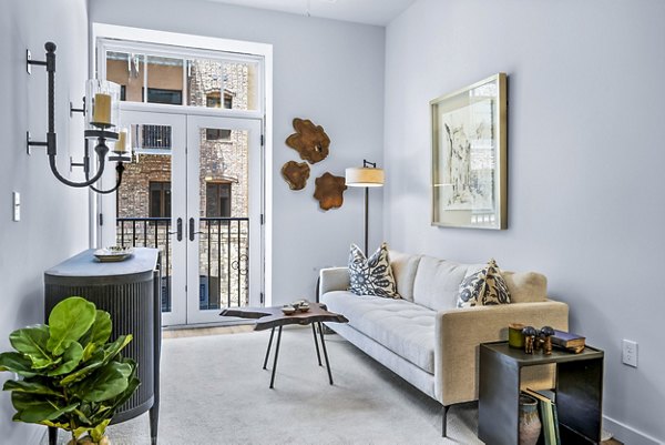 Modern living room with sleek furnishings and ample natural light at Avvio Apartments