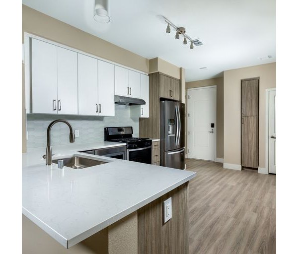 Modern kitchen with stainless steel appliances and island at The Core on Foothill Apartments