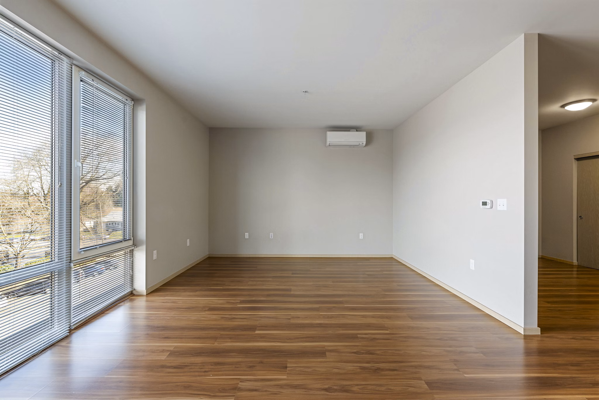 Cozy bedroom with contemporary decor and large windows at Prescott Apartments