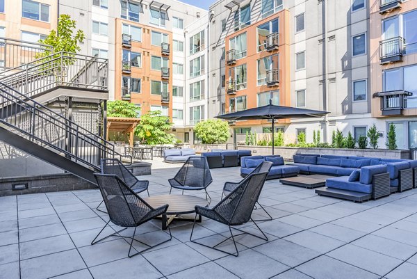 Elegant outdoor patio surrounded by lush greenery at Prescott Apartments, ideal for relaxation in a luxury setting