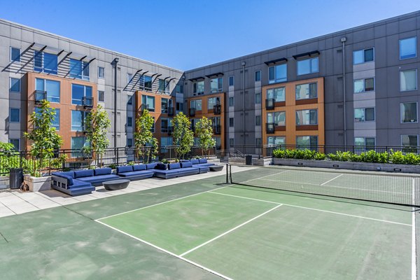 Prescott Apartments: Modern tennis court with lush surroundings in rental community