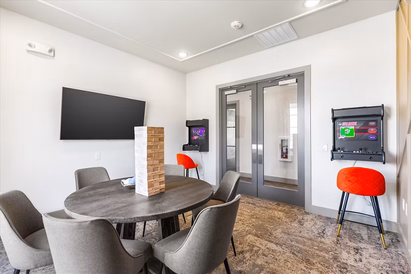 Game room with billiards and arcade games at Emerson at Red Oak Apartments