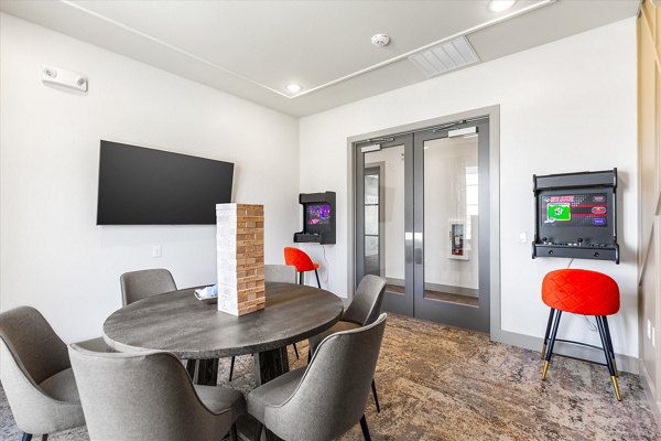 Game room with billiards and arcade games at Emerson at Red Oak Apartments