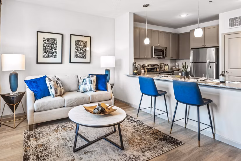 Cozy living room with modern furniture and large windows at Emerson at Red Oak Apartments, a luxury property by Greystar