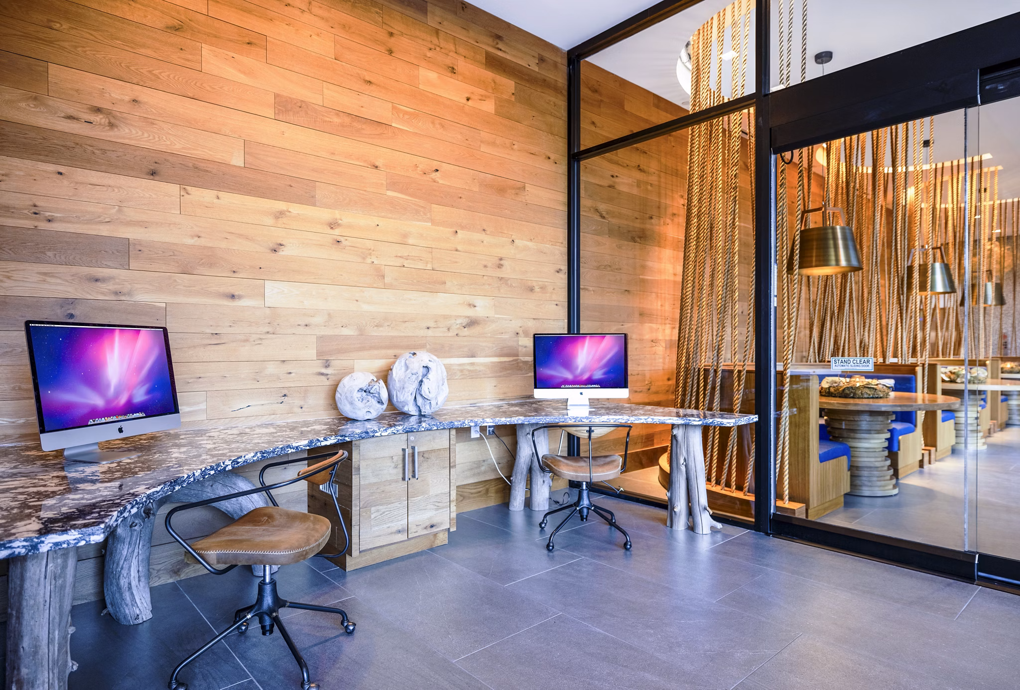 Modern business center with workstations at The Sur Apartments clubhouse, offering a professional workspace for residents