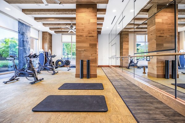 Yoga and spin studio with mirrored walls and exercise bikes at The Sur Apartments in Greystar's luxury community