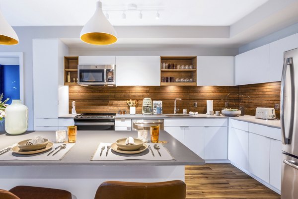 Sleek modern kitchen with island and stainless steel appliances in The Sur Apartments