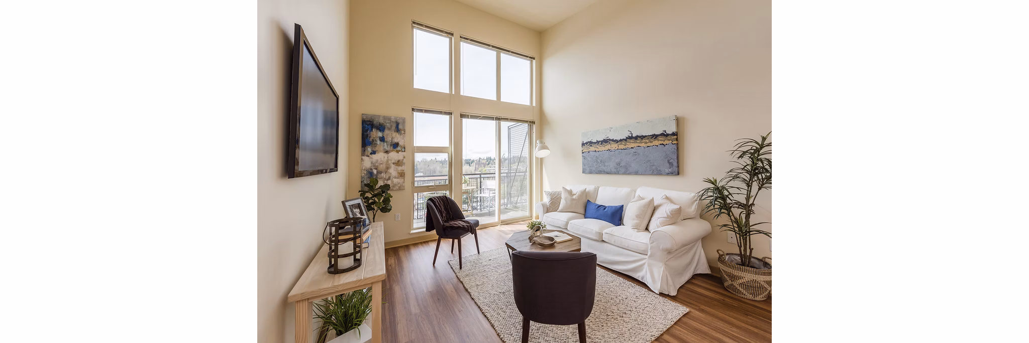 Stylish living room with modern decor and large windows at Thornton Place Apartments