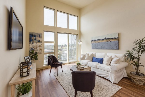 Stylish living room with modern decor and large windows at Thornton Place Apartments