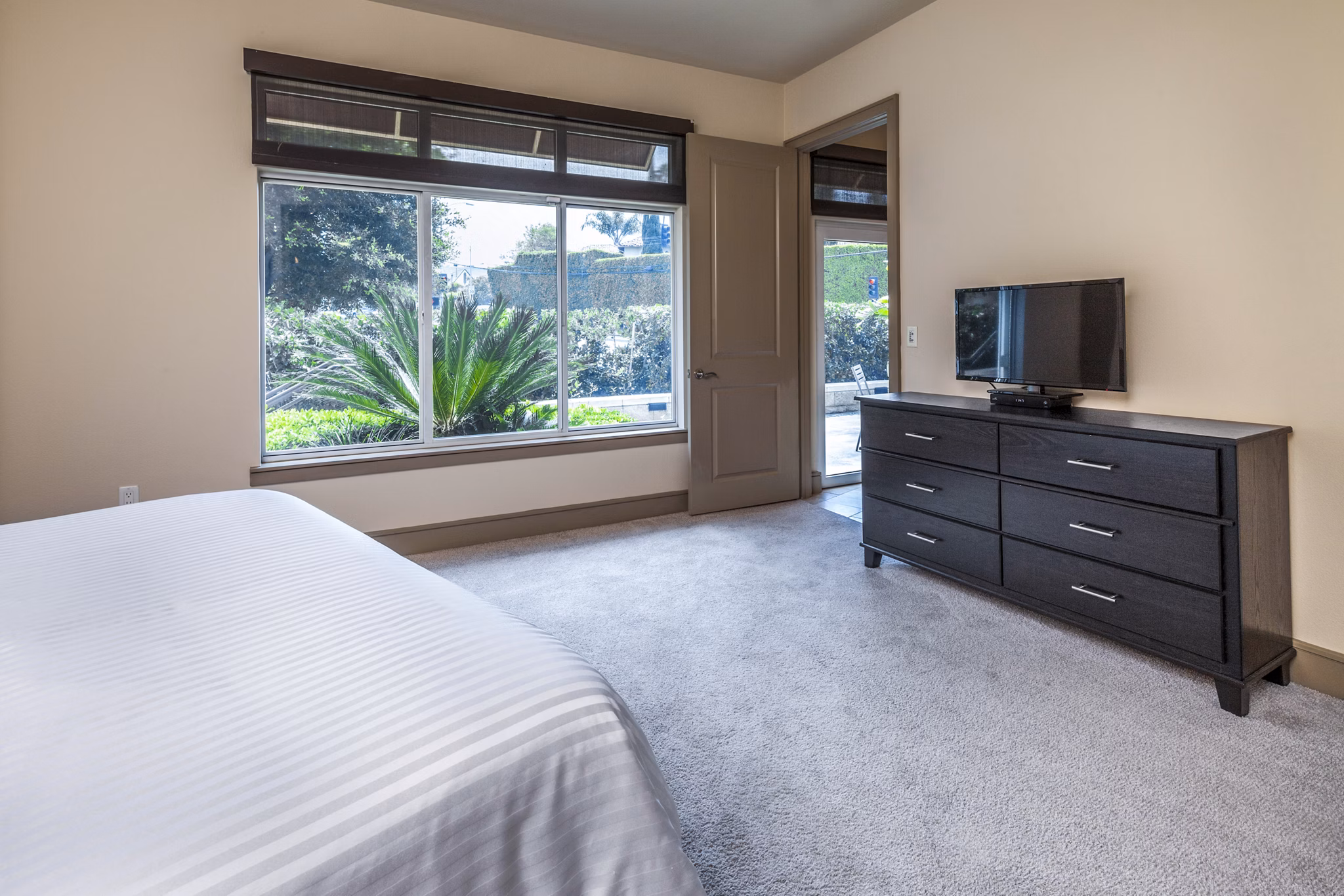 Spacious bedroom with modern furnishings at mResidences Miracle Mile Apartments