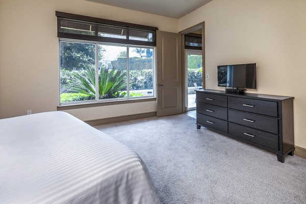 Spacious bedroom with modern furnishings at mResidences Miracle Mile Apartments