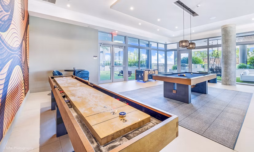 Clubhouse game room with pool table and lounge seating at Beckon Apartments, offering luxury living spaces for residents
