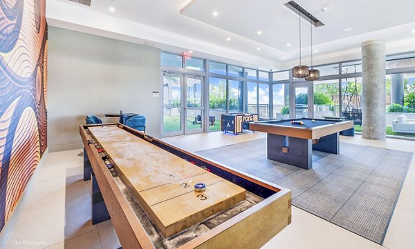 Clubhouse game room with pool table and lounge seating at Beckon Apartments, offering luxury living spaces for residents