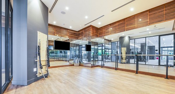 Yoga studio with mirrored walls and wooden floors at Crest at Pinecrest Apartments Ideal for residents seeking a serene fitness space