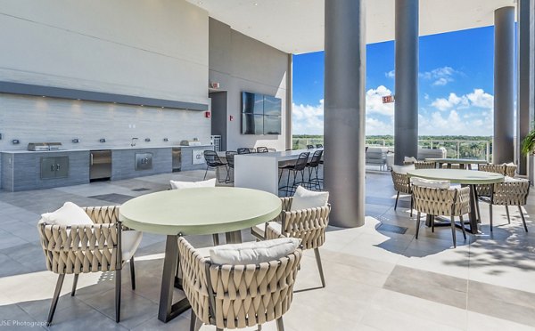 Grill area with modern patio seating at Crest at Pinecrest Apartments