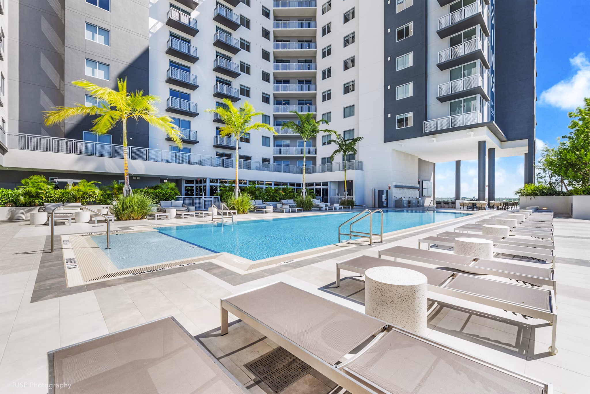 Luxurious pool area with lounging chairs at Crest at Pinecrest Apartments, offering a relaxing retreat in a serene setting