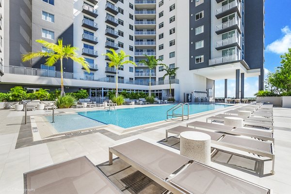 Luxurious pool area with lounging chairs at Crest at Pinecrest Apartments, offering a relaxing retreat in a serene setting