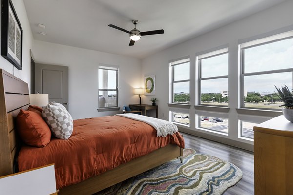 Modern bedroom with elegant decor at Alexan Braker Pointe Apartments, offering luxurious living spaces in a vibrant community setting