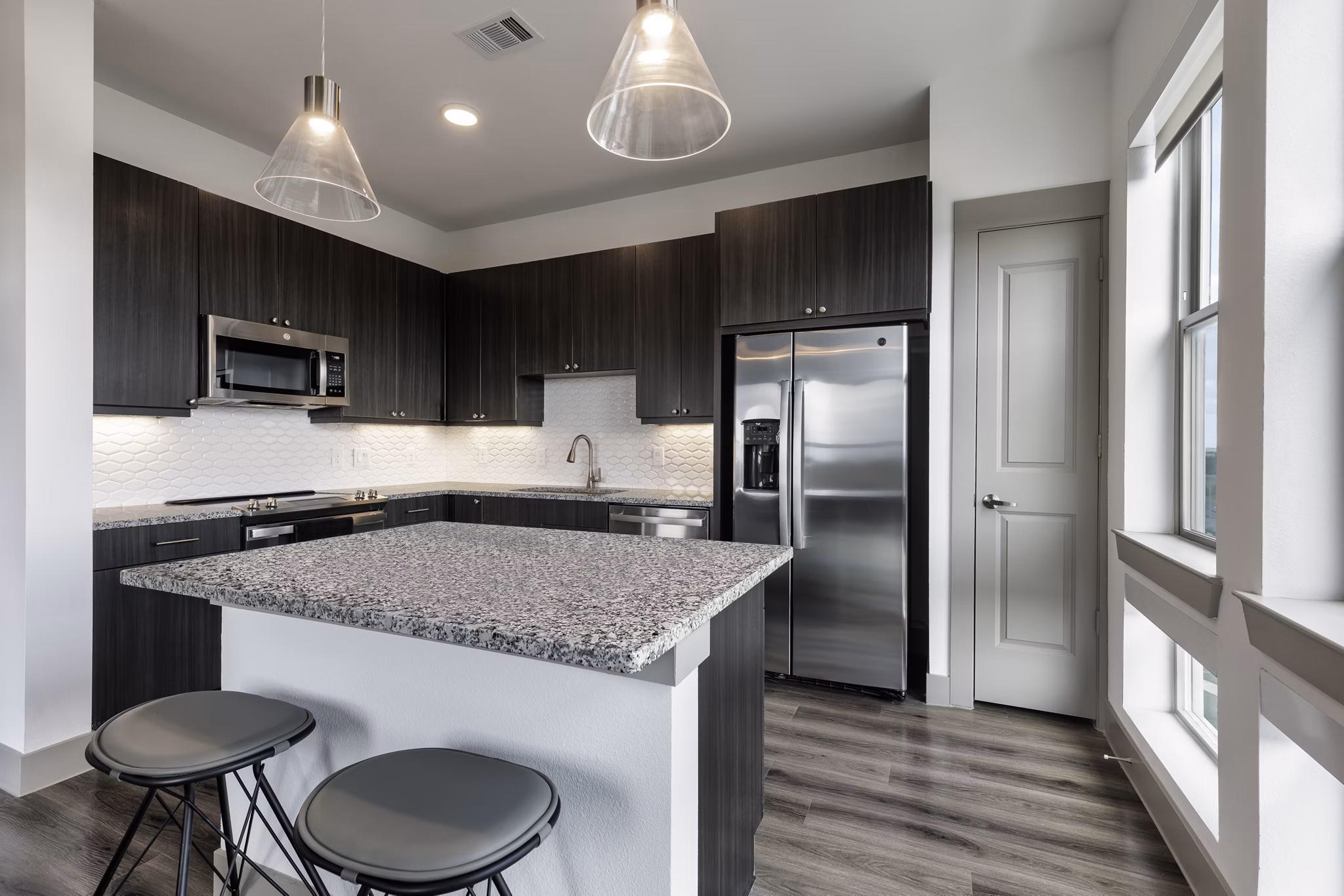 Modern kitchen with sleek countertops and stainless steel appliances at Alexan Braker Pointe Apartments