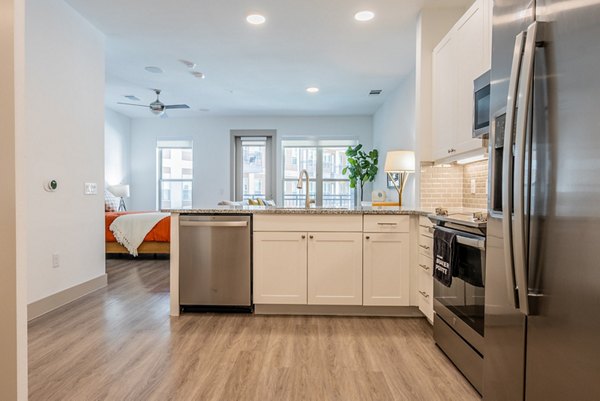 Modern kitchen with stainless steel appliances in Alexan Braker Pointe Apartments