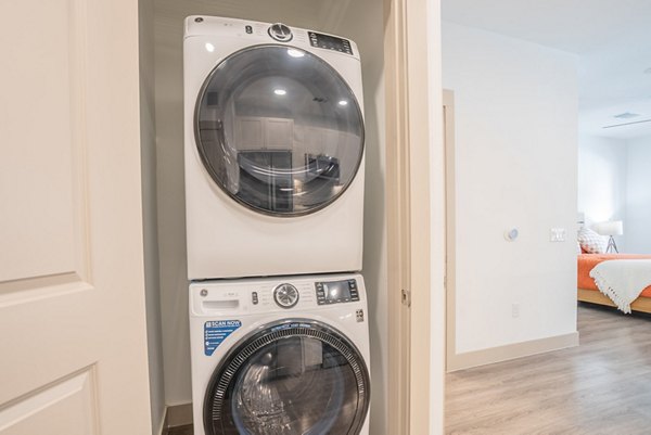 Laundry room with modern appliances at Alexan Braker Pointe Apartments