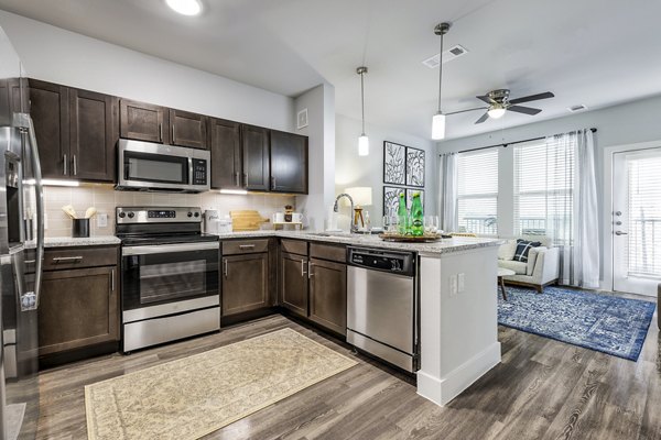Modern kitchen with stainless steel appliances and quartz countertops at Sage Stone Oak Apartments in San Antonio