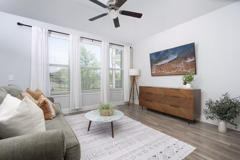 Spacious living room with modern decor in Sage Stone Oak Apartments, featuring comfortable seating and large windows