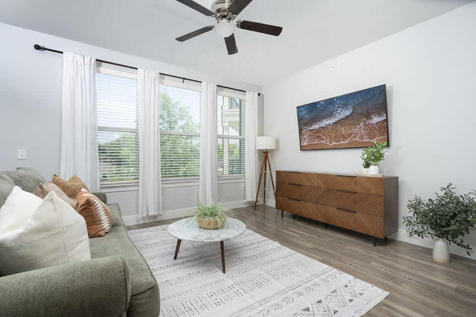 Spacious living room with modern decor in Sage Stone Oak Apartments, featuring comfortable seating and large windows