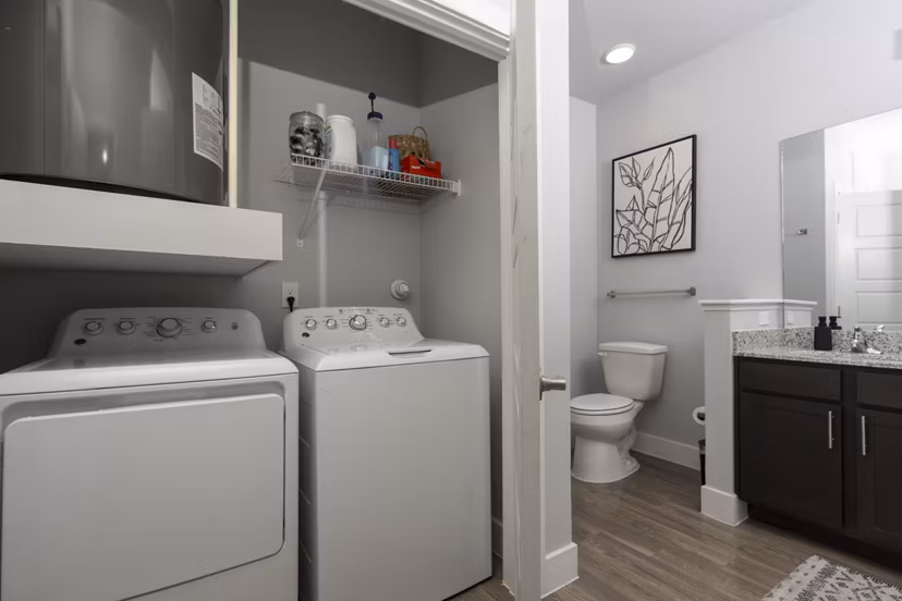Modern laundry room with stainless steel appliances at Sage Stone Oak Apartments in San Antonio