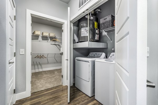 Modern laundry room with stainless steel appliances at Sage Stone Oak Apartments in San Antonio
