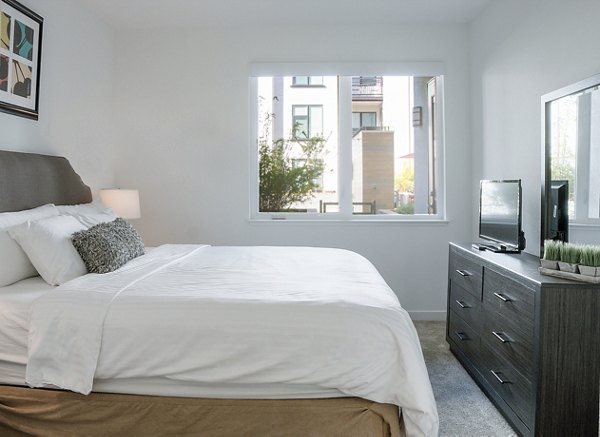 Bedroom with modern decor, large windows, and mountain views at mResidences Mountain View Apartments