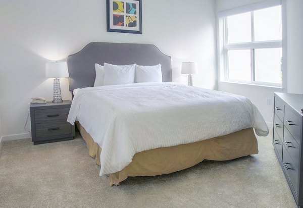 Cozy bedroom with modern furnishings at mResidences Mountain View Apartments, perfect for luxury living in a serene environment