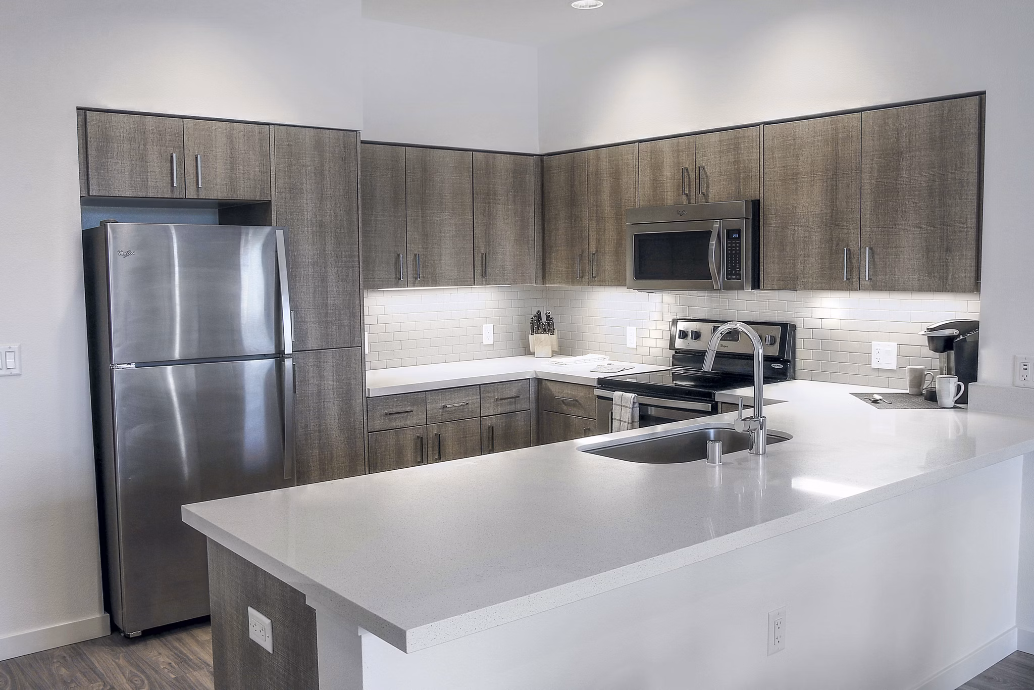 Kitchen with sleek countertops and modern appliances in mResidences Mountain View Apartments