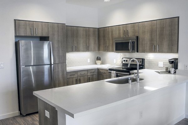 Kitchen with sleek countertops and modern appliances in mResidences Mountain View Apartments