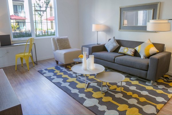 Modern living room with sleek furnishings and large windows at mResidences Mountain View Apartments, offering luxury living in a serene location