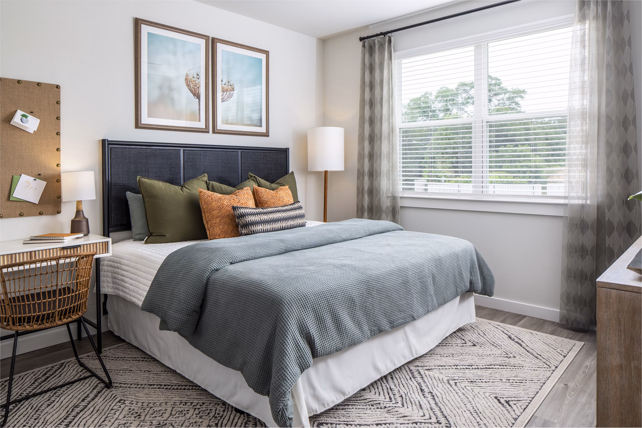 Cozy bedroom featuring a comfortable bed, desk, and natural light from a window
