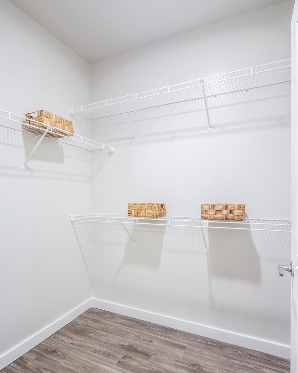 Empty closet with wire shelving and wicker baskets in luxury apartment
