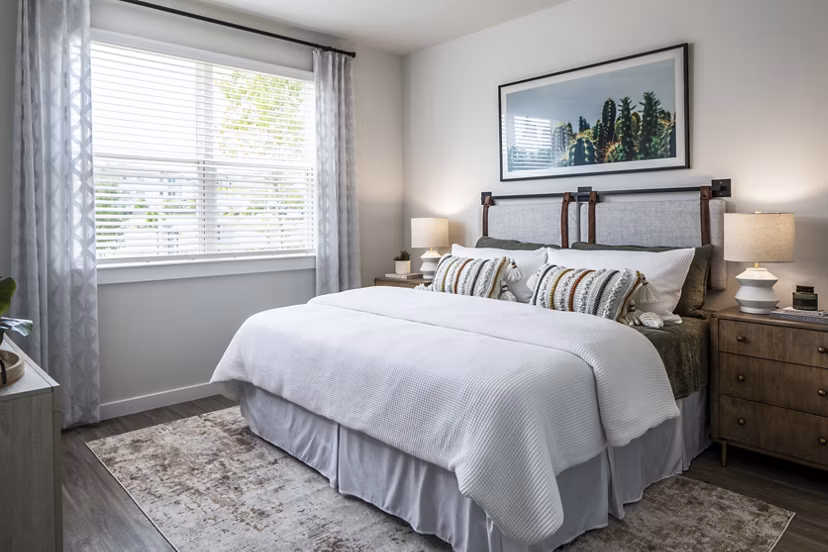Cozy bedroom with a comfortable bed, nightstands, and window in luxury apartments