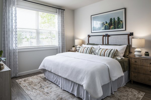 Cozy bedroom with a comfortable bed, nightstands, and window in luxury apartments