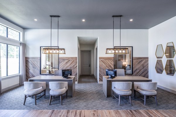 Modern office reception area with desks, chairs, and decorative mirrors in luxury apartment community