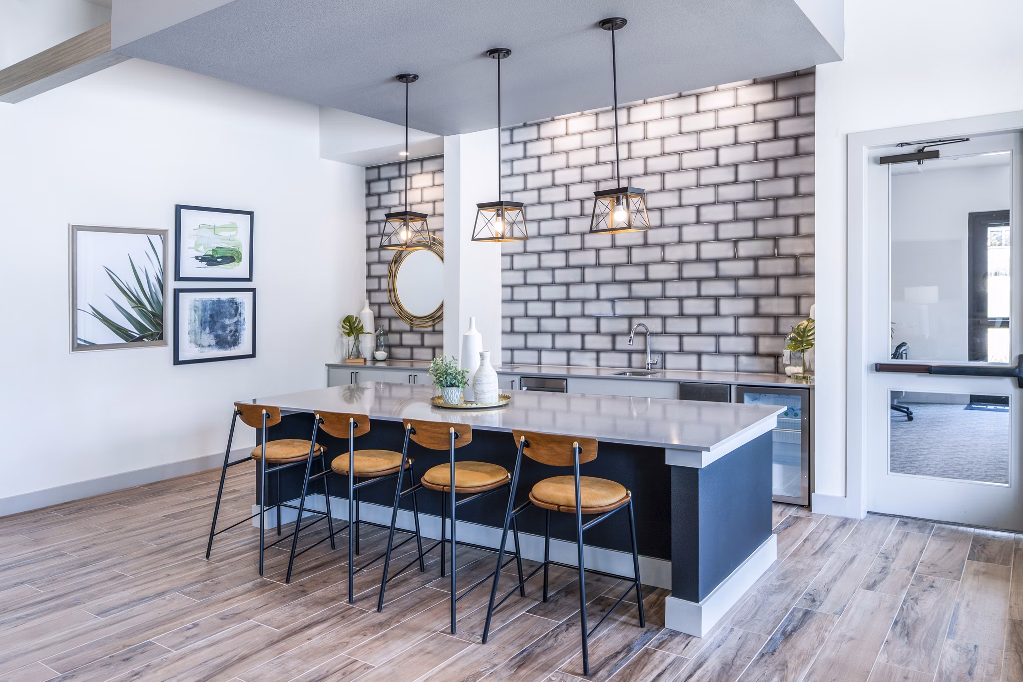 Modern kitchen with a large island, bar stools, and decorative wall art in luxury apartments