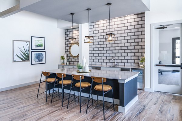 Modern kitchen with a large island, bar stools, and decorative wall art in luxury apartments