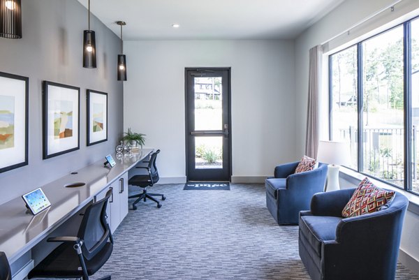 Modern office space with desks, chairs, and wall art featuring large windows in luxury apartments