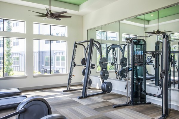Well-equipped gym with treadmills and weight machines in luxury apartments